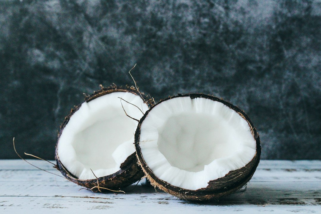 Fresh cracked coconut on a clean wooden surface