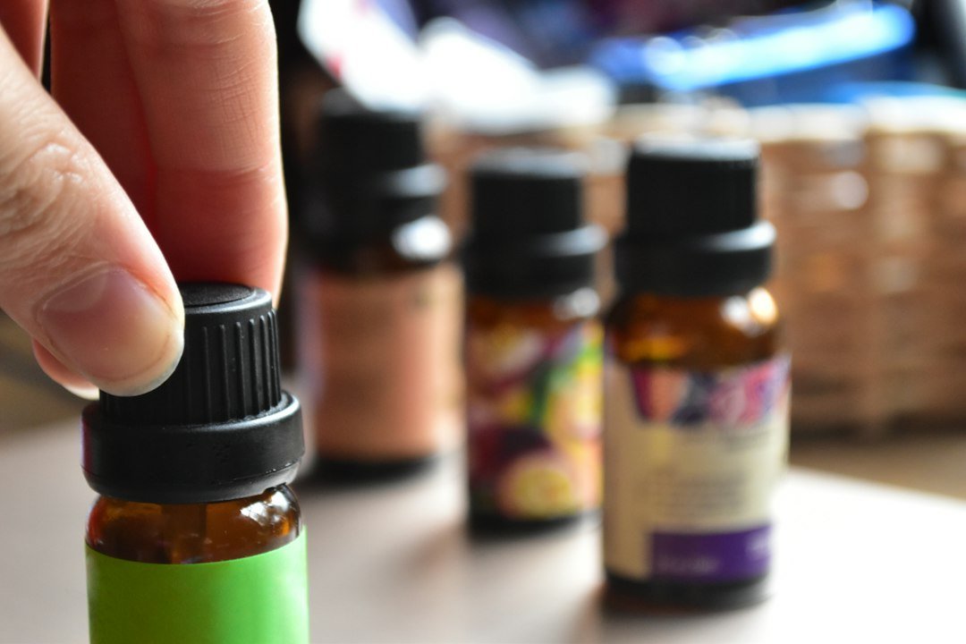 Person selecting an essential oil bottle